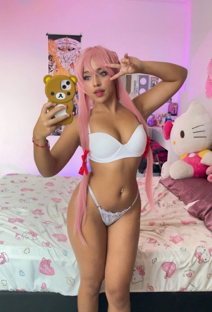 Ele Villa in look cosplay anime con parrucca rosa e codini davanti allo specchio
